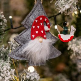 Close-up of charming holiday decorations on a Christmas tree with festive lights.